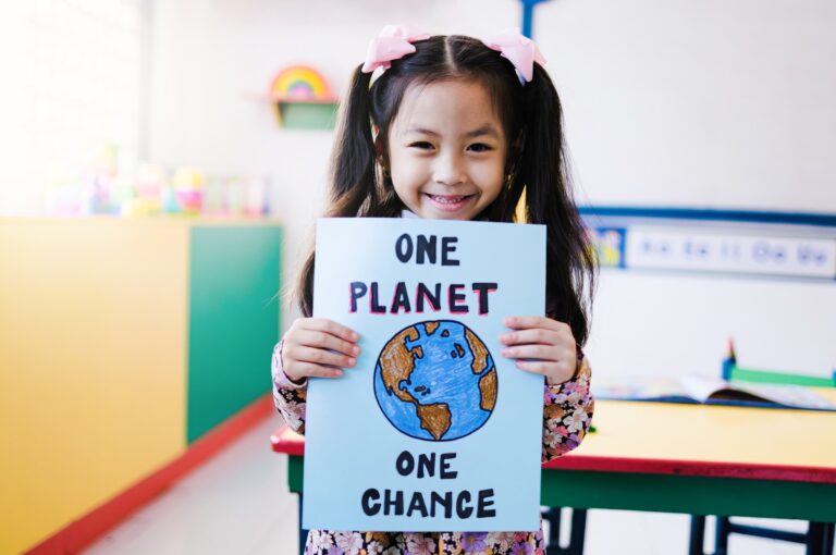 Asian,Kid,Holding,Climate,Change,Banner,With,Class,Room,School